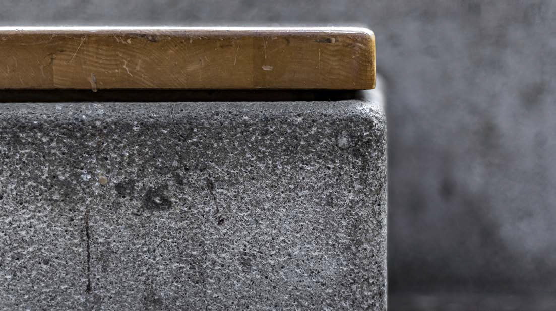 Close-up side view of a stone bench